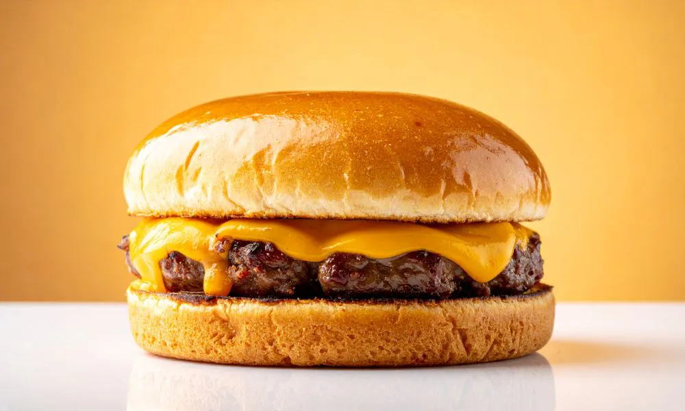 Juicy cheeseburger with melted cheddar on a toasted bun at Acbento, a Fast Food Restaurant in Flushing