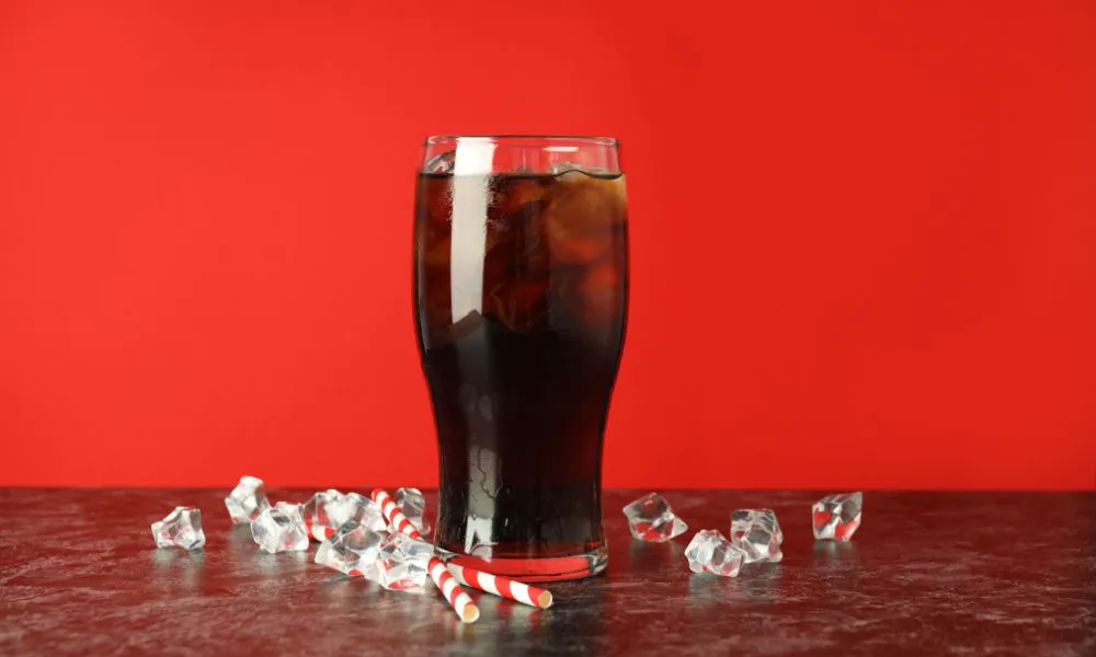 A glass of iced cola with ice cubes and red straws at Acbento, a Fast Food Restaurant in Flushing